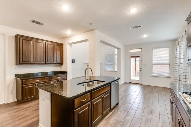 a kitchen that has a sink a stove and cabinets