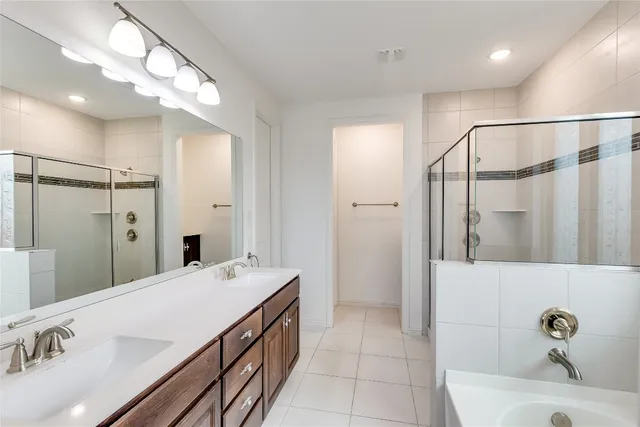 a bathroom with a tub sink shower and mirror