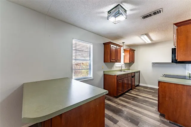 a kitchen with stainless steel appliances granite countertop a stove a sink and a microwave
