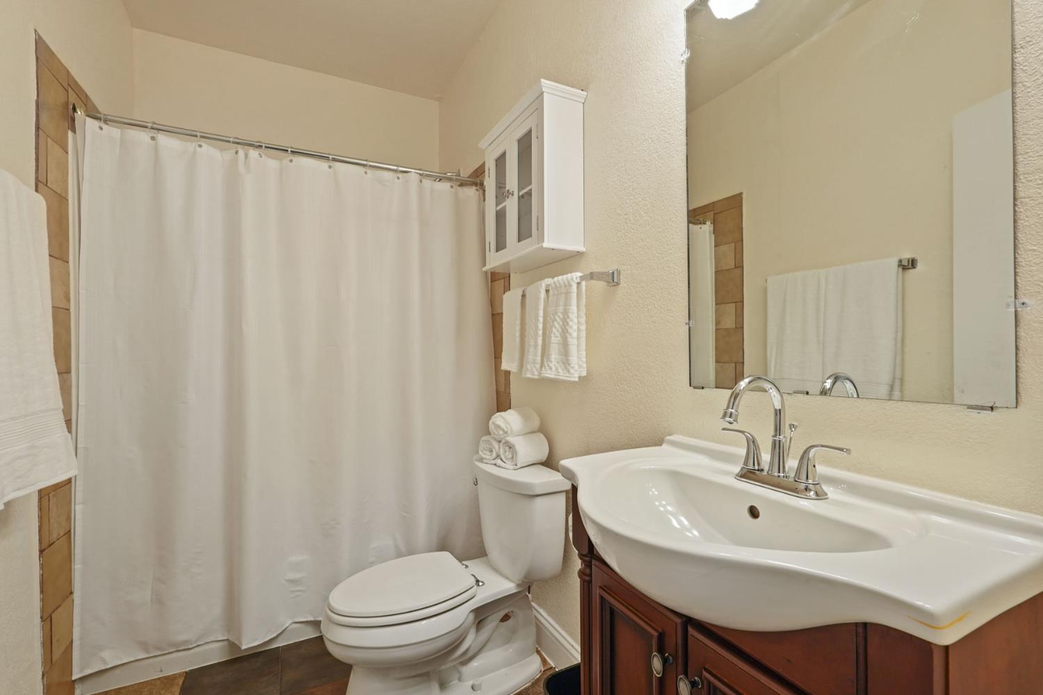 715 North Sutter Street Stockton, CA 95202 - Photo 29 of 51 a bathroom with a sink a toilet and a mirror