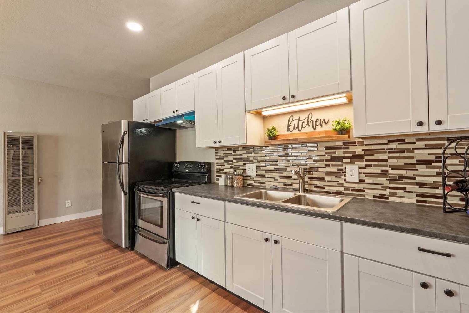 715 North Sutter Street Stockton, CA 95202 - Photo 39 of 51 a kitchen with granite countertop white cabinets and stainless steel appliances