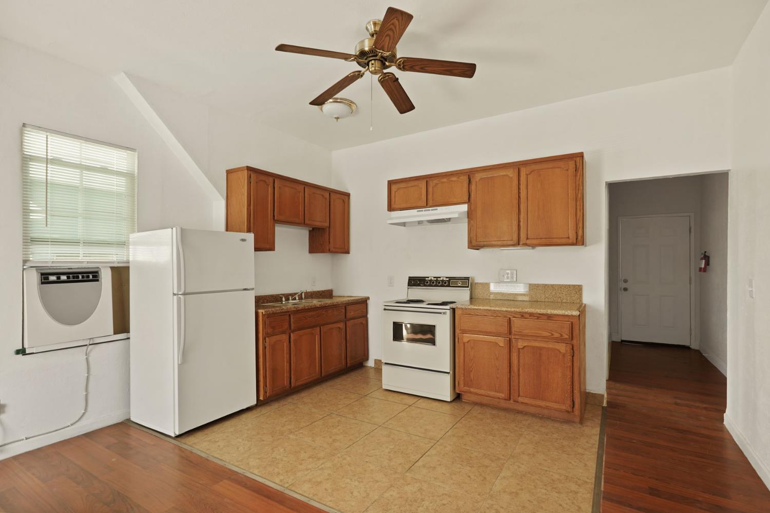 715 North Sutter Street Stockton, CA 95202 - Photo 10 of 51 a kitchen with stainless steel appliances granite countertop a refrigerator a stove a sink dishwasher and a stove with wooden floor