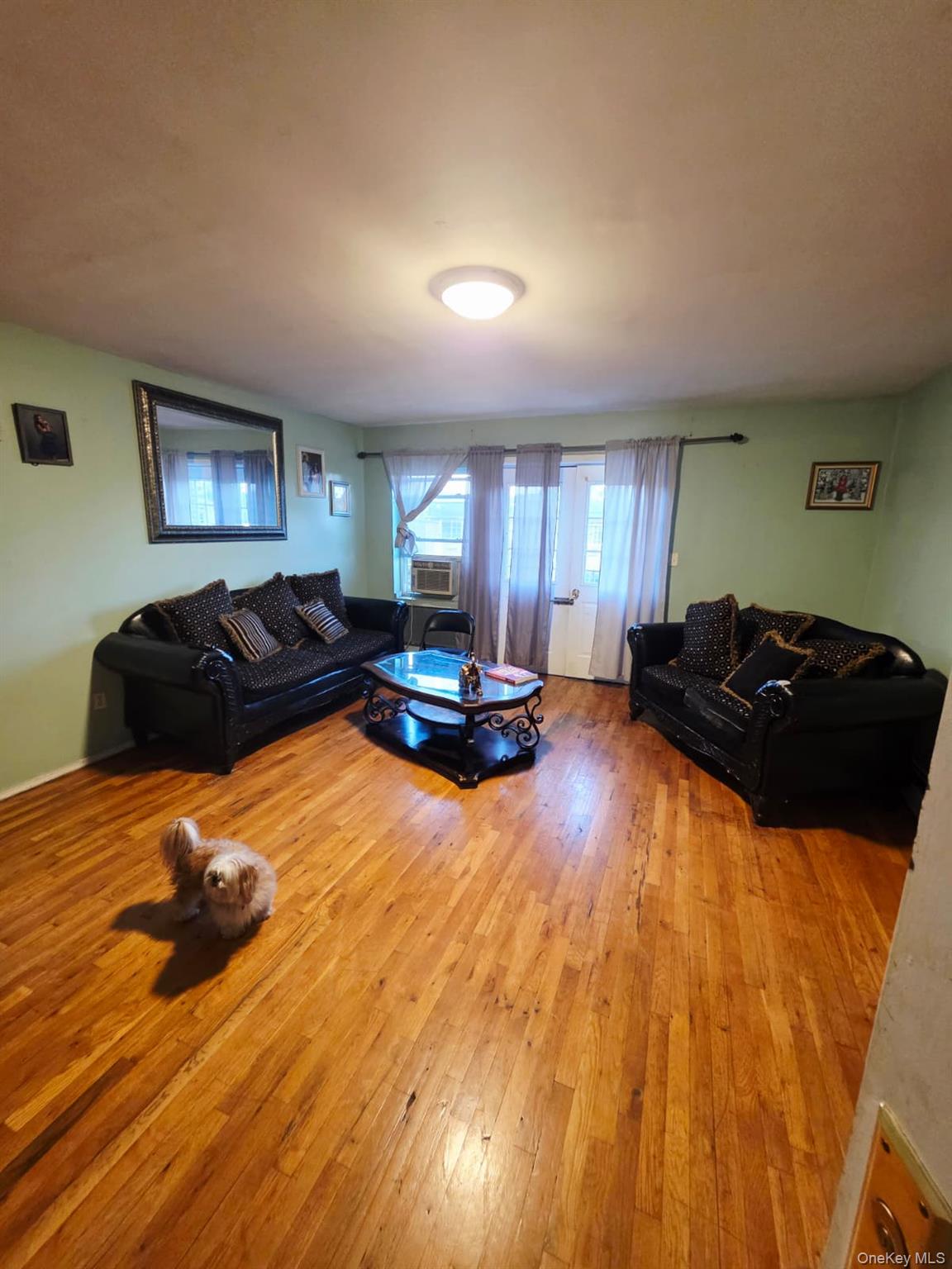 93-26 197th Street, Unit 3 Queens, NY 11423 - Photo 2 of 9 a large bedroom with a bed and wooden floor