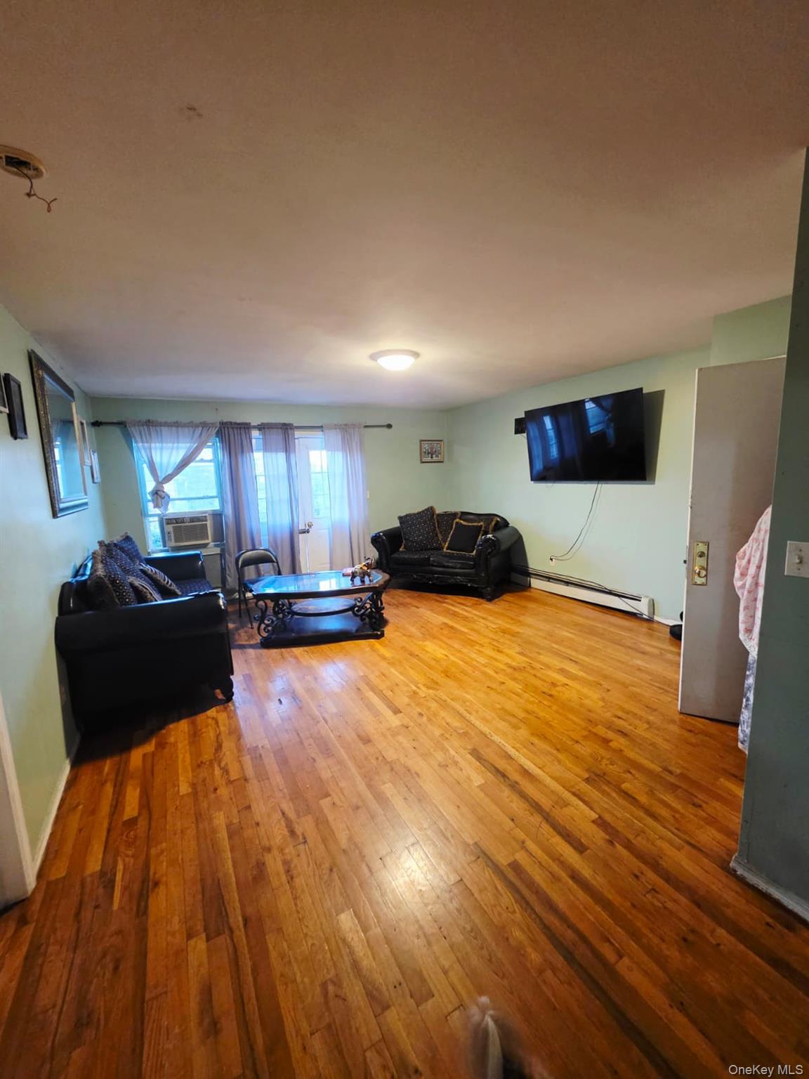 93-26 197th Street, Unit 3 Queens, NY 11423 - Photo 3 of 9 a bedroom with a bed and wooden floor