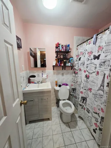 a bathroom with a sink toilet and shower curtain