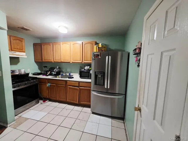 a kitchen with stainless steel appliances granite countertop a refrigerator and a stove top oven