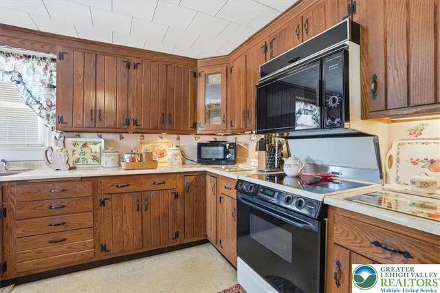 a kitchen with granite countertop wooden cabinets and a stove top oven