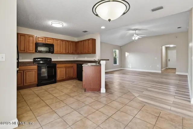 a kitchen with stainless steel appliances granite countertop a stove top oven a sink a counter space and cabinets