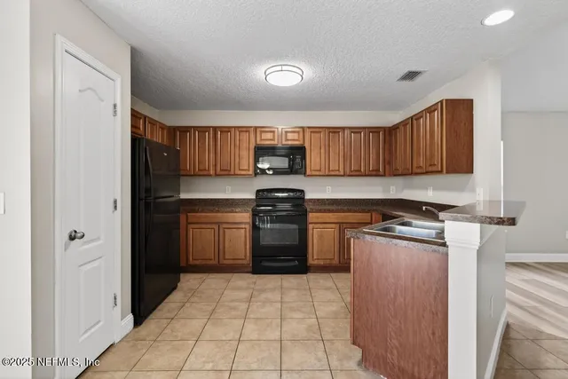 a kitchen with a refrigerator sink and cabinets