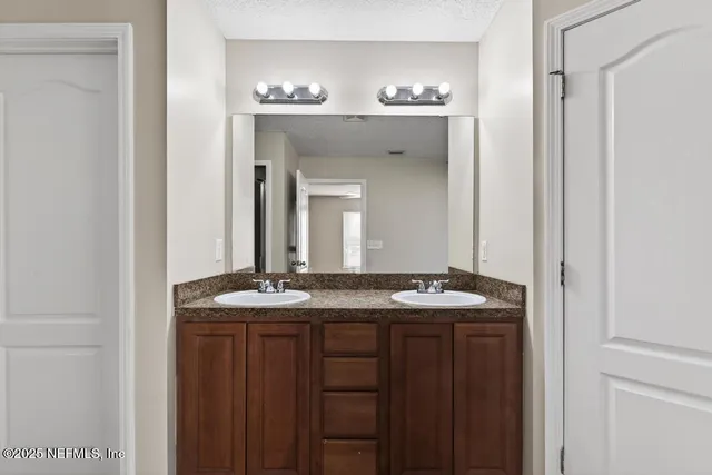 a bathroom with a granite countertop sink a large mirror and a vanity