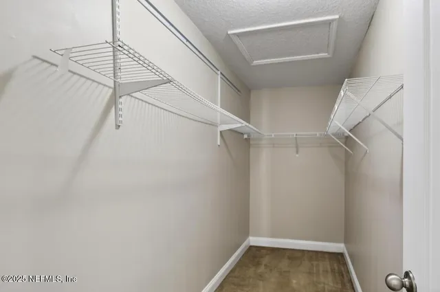 a view of walk in closet with empty racks