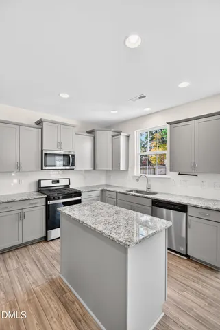 a kitchen with stainless steel appliances granite countertop a sink stove and refrigerator