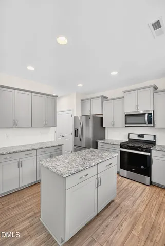 a kitchen with stainless steel appliances granite countertop a stove sink and cabinets