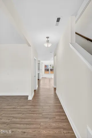 a view of an empty room with wooden floor