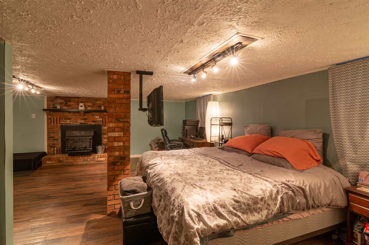 3391 Oak Ridge Road Mount Crawford, VA 22841 - Photo 20 of 27 a bed sitting in a spacious bedroom next to a fireplace with wooden floor