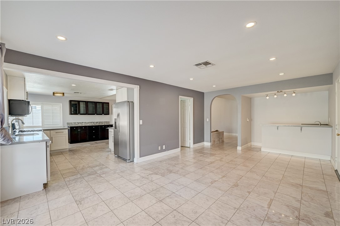6635 Costa Brava Road Las Vegas, NV 89146 - Photo 18 of 59 Seamless tile flooring connects this modern kitchen with a versatile open living area, featuring a convenient wet bar.