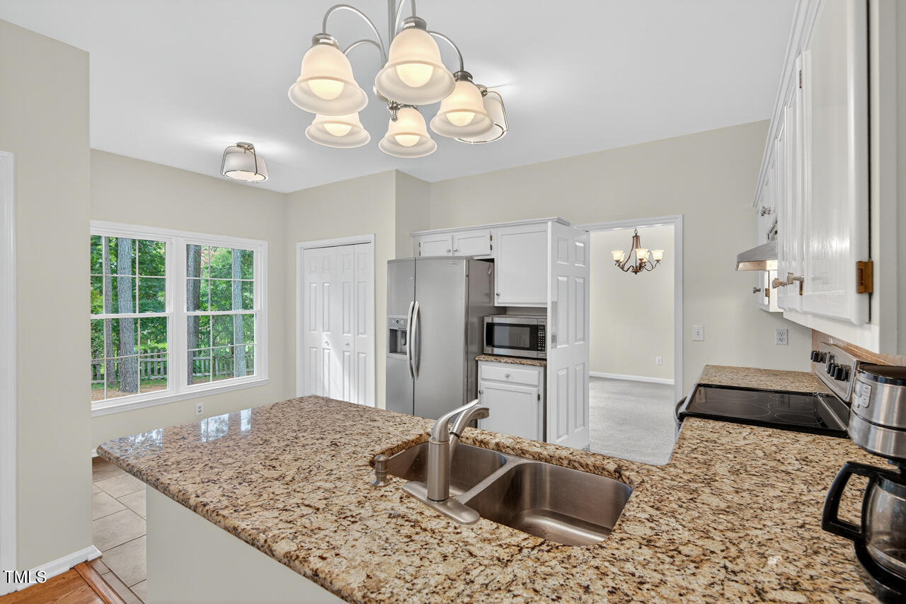 8825 Kirkstall Court Raleigh, NC 27615 - Photo 19 of 49 a kitchen with stainless steel appliances granite countertop a sink refrigerator stove and refrigerator