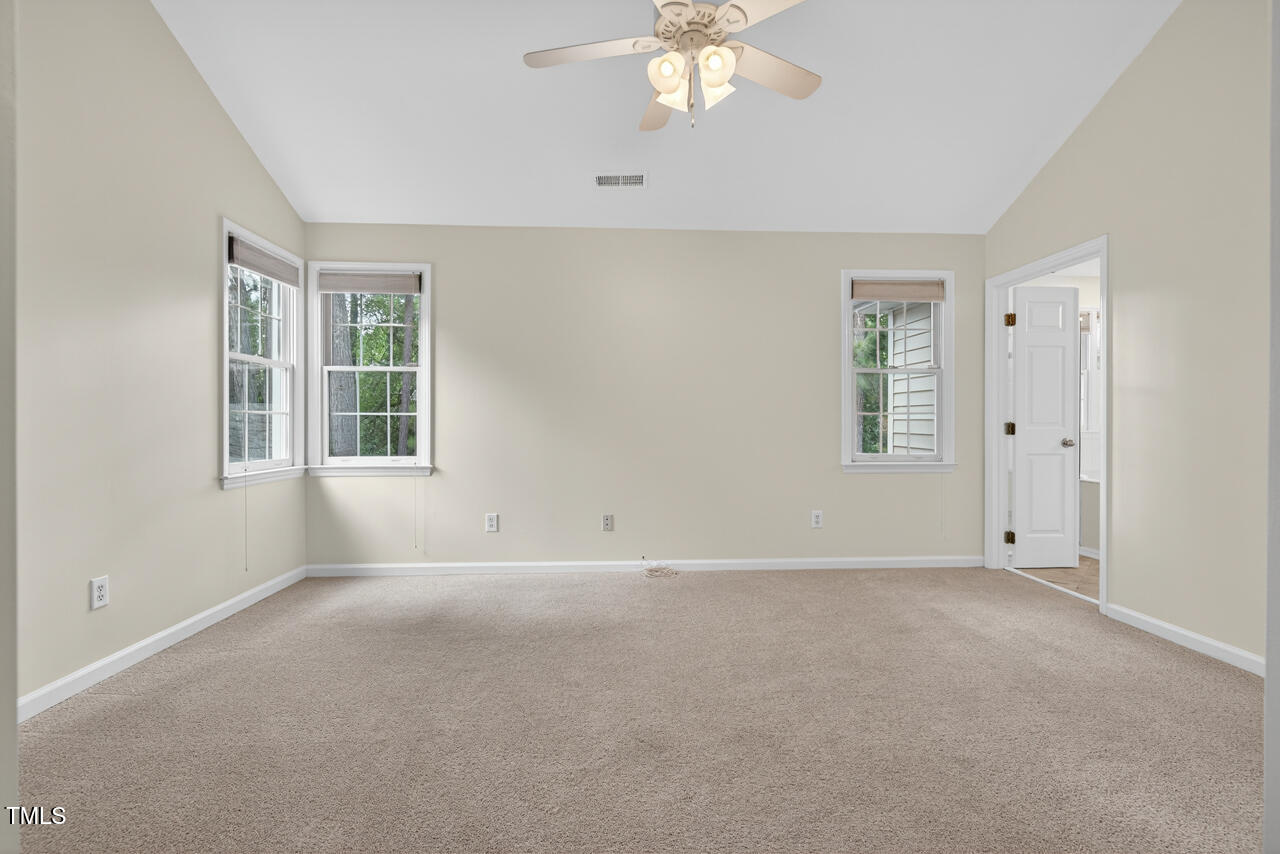 8825 Kirkstall Court Raleigh, NC 27615 - Photo 28 of 49 an empty room with windows and chandelier fan
