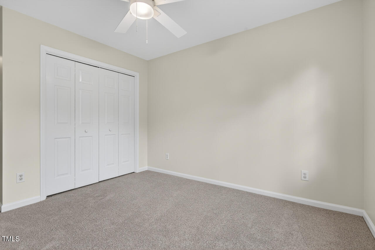 8825 Kirkstall Court Raleigh, NC 27615 - Photo 33 of 49 an empty room with a ceiling fan and a window