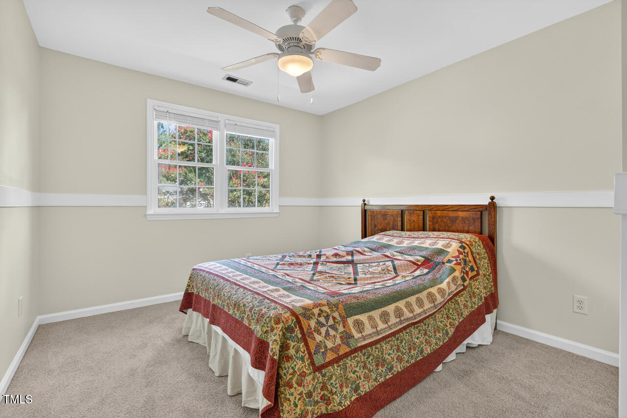 8825 Kirkstall Court Raleigh, NC 27615 - Photo 34 of 49 a bedroom with a bed and a chandelier