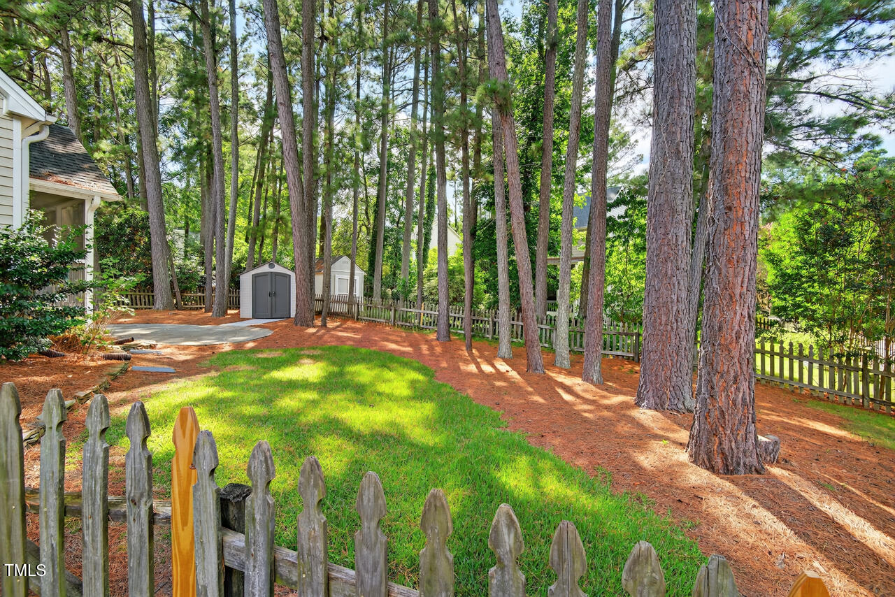8825 Kirkstall Court Raleigh, NC 27615 - Photo 39 of 49 a view of a patio with table and chairs and wooden fence