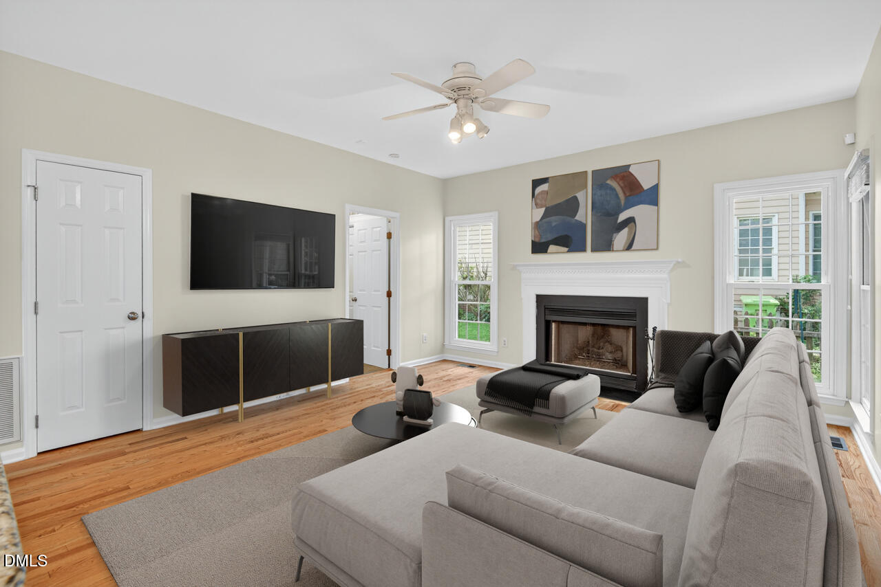 8825 Kirkstall Court Raleigh, NC 27615 - Photo 9 of 49 a living room with furniture a flat screen tv and a fireplace
