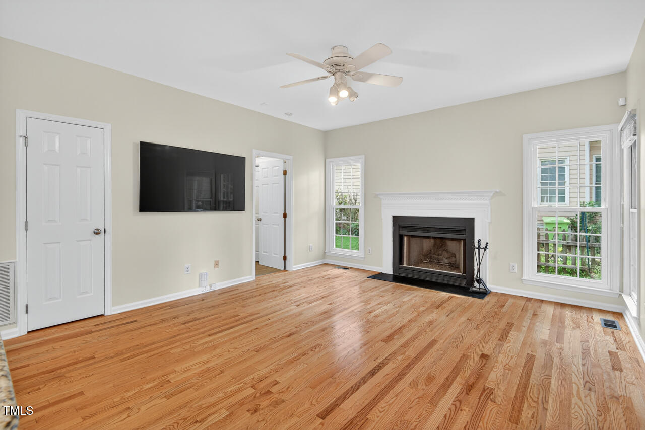 8825 Kirkstall Court Raleigh, NC 27615 - Photo 10 of 49 a view of empty room with wooden floor and fireplace