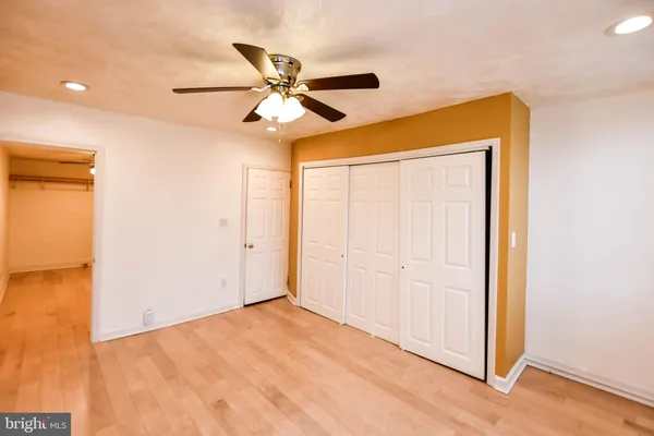 an empty room with a ceiling fan and a window