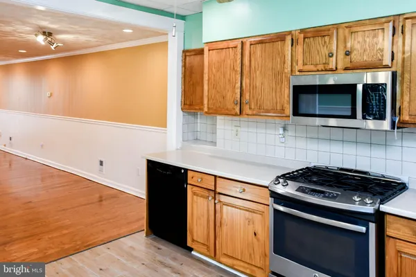 a kitchen with granite countertop wooden cabinets and a stove top oven