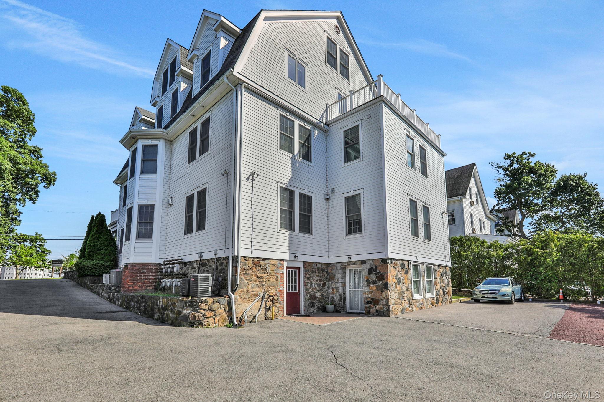 2 Harbor Lane, Unit 301 New Rochelle, NY 10805 - Photo 6 of 33 a view of a white building among the street with palm trees
