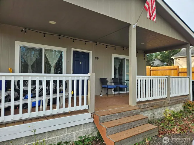 a view of a porch with wooden floor and floor to ceiling window