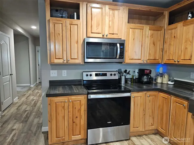 a kitchen with granite countertop a stove a sink and a microwave
