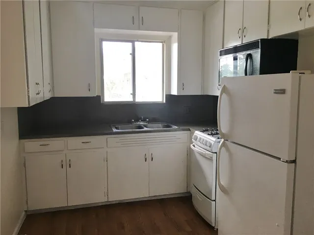 a kitchen with cabinets appliances and a window