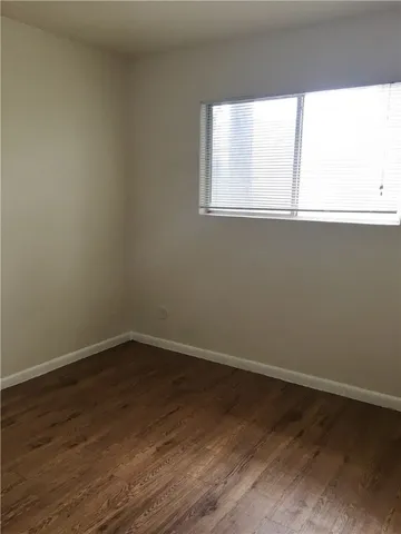 a view of a small space with wooden floor and a window