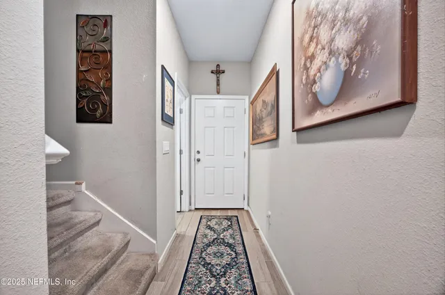a view of hallway with wooden floor and stairs