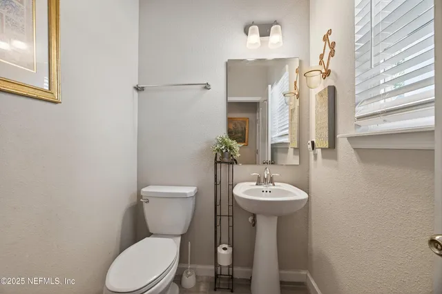 a bathroom with a toilet sink and a mirror