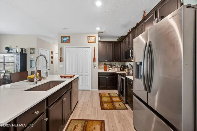 a kitchen with stainless steel appliances a refrigerator sink and white cabinets
