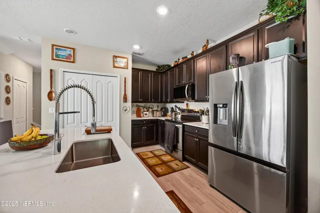 a kitchen with stainless steel appliances granite countertop a refrigerator sink and stove