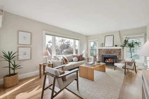 a living room with furniture large window and a fireplace