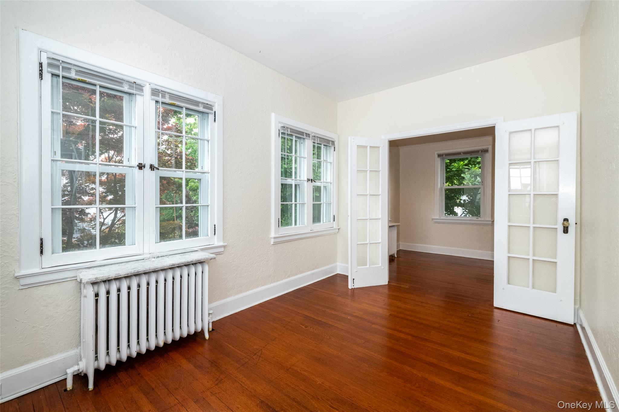 82 Clove Road New Rochelle, NY 10801 - Photo 21 of 39 a view of an empty room with wooden floor and windows