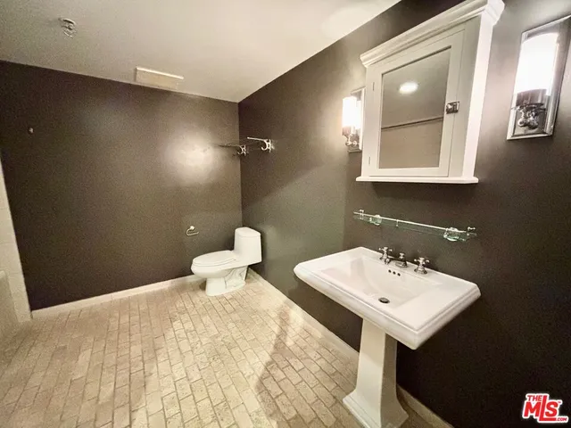 a bathroom with a sink mirror and toilet