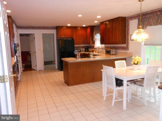 3603 Jackson Cabin Road Phoenix, MD 21131 - Photo 22 of 30 a kitchen with stainless steel appliances kitchen island granite countertop a table chairs sink and cabinets