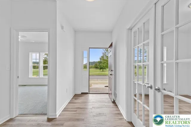 a view of a hallway with wooden floor and windows