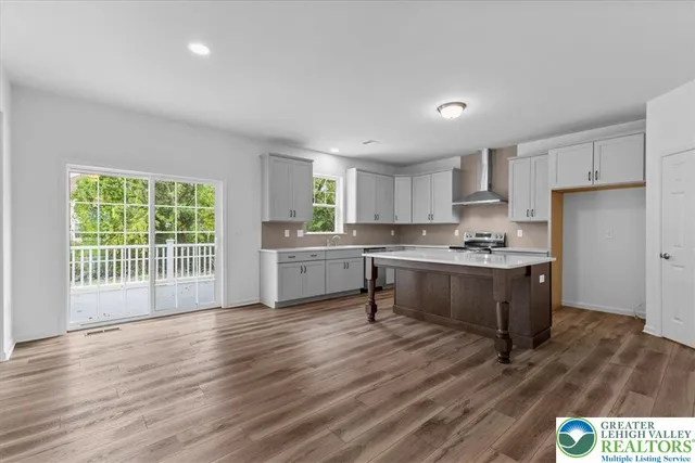 a kitchen with a refrigerator a sink dishwasher with a dining table and wooden floor