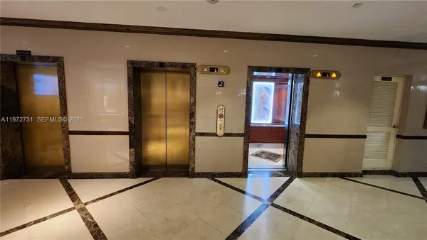 a view of a refrigerator in an empty room
