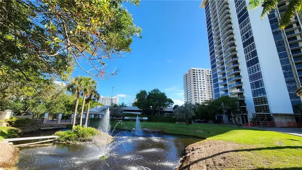 a view of a swimming pool with a yard and a fountain
