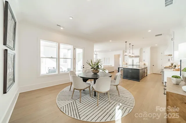 a living room with furniture a dining table and a large window