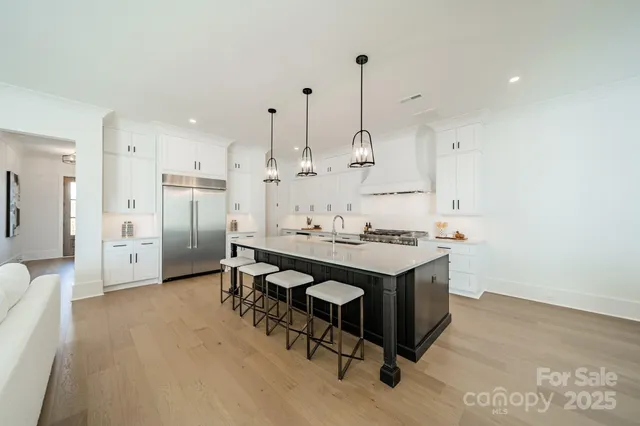 a open kitchen with stainless steel appliances granite countertop a sink a stove and a refrigerator