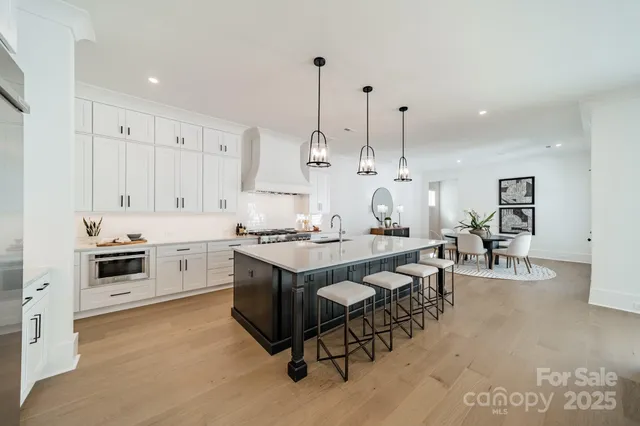 a large kitchen with kitchen island a stove a sink a dining table and chairs