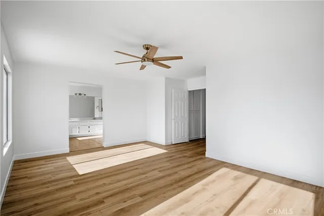 a view of a livingroom with wooden floor and a ceiling fan